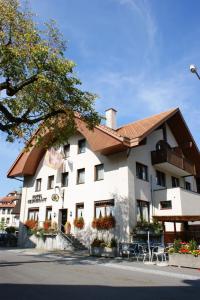 un grand bâtiment blanc avec un toit marron dans l'établissement Hotel & Restaurant Sonne, à Schwarzenburg