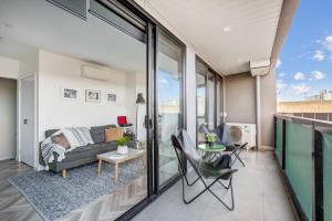 ein Wohnzimmer mit einem Sofa und einem Tisch in der Unterkunft Contemporary Apt, cafes, wifi, tram, parking in Melbourne
