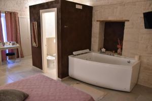 Habitación con baño con bañera blanca grande. en Antico Corso 74, en Sammichele di Bari