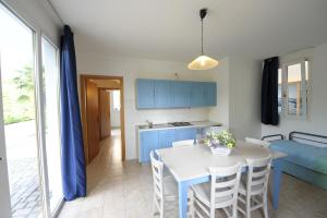 a kitchen and dining room with a white table and chairs at Camping Bella Italia in Peschiera del Garda