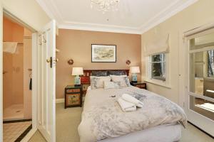 Un dormitorio con una cama grande y una lámpara de araña. en Woodford House of Leura, en Leura