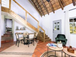a living room with a table and chairs at Simbavati Mvubu Cottage in Timbavati Game Reserve