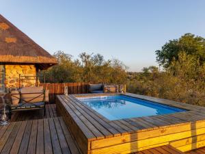 a swimming pool on a wooden deck with a deck at Simbavati Mvubu Cottage in Timbavati Game Reserve