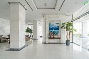 a lobby with a painting on the wall and a palm tree at Exclusive GLOBALSTAY Apartments in Business Bay Free Parking & More! in Dubai