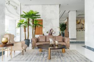 un soggiorno con divano, tavoli e palme di Exclusive GLOBALSTAY Apartments in Business Bay Free Parking & More! a Dubai
