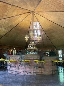 a group of chairs and a bar in a tent at Octagon Lodge in Karatu