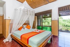 a bedroom with a bed with a canopy at Sulendra Jungle Suites Ubud View by EPS in Ubud