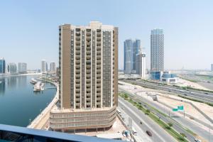 a tall building next to a river in a city at Exclusive GLOBALSTAY Apartments in Business Bay Free Parking & More! in Dubai