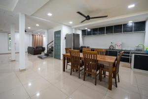 een keuken en eetkamer met een tafel en stoelen bij Jack Guest House KB 5 Rooms 4 Toilets - Max 20 pax in Kota Bharu