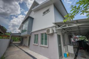 een wit huis met groene luiken bij Jack Guest House KB 5 Rooms 4 Toilets - Max 20 pax in Kota Bharu