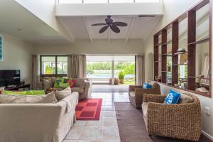 sala de estar con sofás y ventilador de techo. en Muri Beach Villa, en Rarotonga