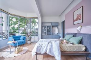 1 dormitorio con 1 cama y 1 sofá azul en M Village Lý Chính Thắng en Ho Chi Minh