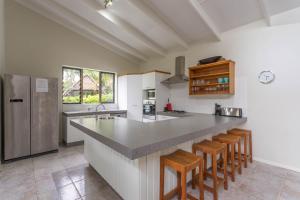 a kitchen with a large counter with stools in it at Muri Beach Villa in Rarotonga