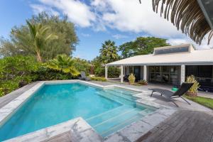 a swimming pool in the backyard of a house at Muri Beach Villa in Rarotonga