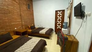 Zimmer mit 2 Betten und TV in der Unterkunft Homestay Candi Pawon Fahrurohman Syariah in Mendut