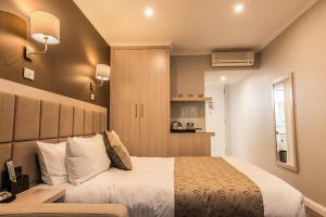 a bedroom with a large white bed in a room at The Waverley International Hotel in Glen Waverley +43 photos