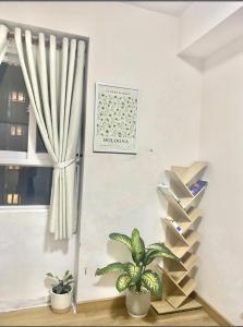 een woonkamer met een trap en twee planten bij Phòng riêng căn hộ SKY9 đầy đủ tiện ích in Ho Chi Minh-stad