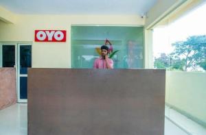 un homme debout derrière un comptoir dans un bâtiment dans l'établissement HOTEL SLN INN, à Bangalore