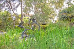 a statue of birds in the grass in a park at Afrique Boutique Hotel O.R. Tambo in Boksburg +71 photos