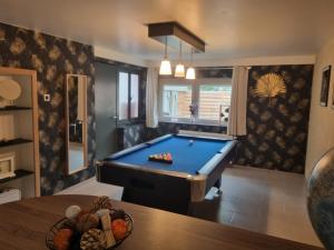 a pool table in a living room with a pool at Maison de vacances aux portes des Fagnes in Hamoir
