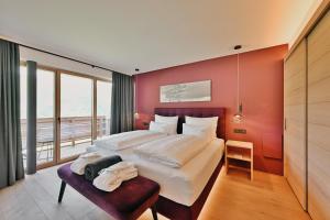 a bedroom with a large bed and a large window at Chalet Hohe Welt - luxury apartments in Lech am Arlberg