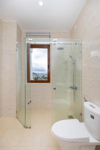 a bathroom with a toilet and a glass shower at Palm Villa Đà Lạt 5 - Luxury Villa khu Villa Đồi An Sơn in Da Lat
