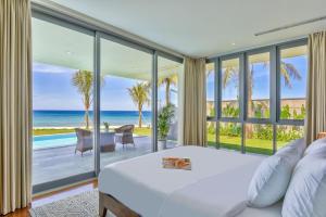 a bedroom with a bed and a view of the ocean at Luxury Pool Villa Close To The Private Beach in Danang