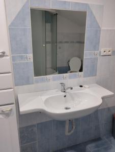 een badkamer met een witte wastafel en een spiegel bij Apartmán U Švejdy in Skuhrov nad Bělou