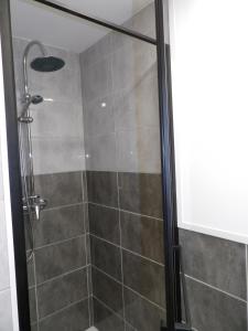 La salle de bains est pourvue d'une douche avec une porte en verre. dans l'établissement Cosy studio au bord de la plage, à Gruissan