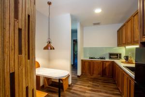 a kitchen with wooden cabinets and a table at Tira Vilagna Suites & Spa in Kintamani