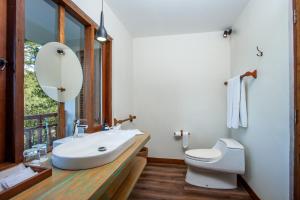 a bathroom with a sink and a toilet and a mirror at Tira Vilagna Suites & Spa in Kintamani
