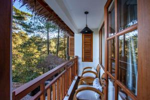 een balkon met stoelen en uitzicht op het bos bij Tira Vilagna Suites & Spa in Kintamani