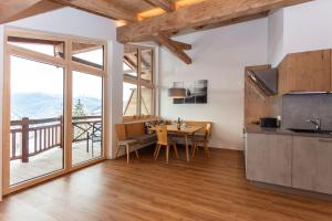 een keuken en eetkamer met een tafel en een balkon bij Moarhof in Unken