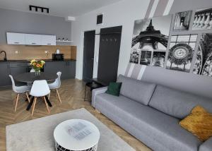 Sala de estar con sofá gris y mesa en Dotis Apartman Tata, en Tata