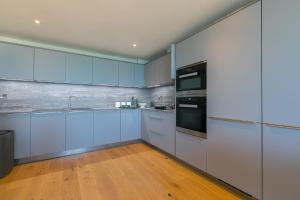 una cocina con armarios azules y electrodomésticos de acero inoxidable en The Oyster, en St Ives