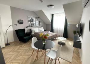 1 dormitorio con 1 cama, mesa y sillas en Dotis Apartman Tata, en Tata