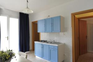 a kitchen with blue cabinets and a sink at Camping Bella Italia in Peschiera del Garda