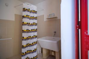 a bathroom with a sink and a shower curtain at Villa Elena in Porto Cesareo