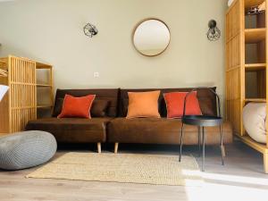 a living room with a brown couch with orange pillows at Estudio reformado Vall d'Incles Grandvalira, 4 pers, max 2 adultos y 2 niños menores 12 años in Canillo