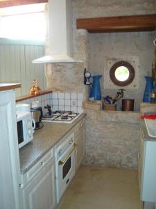 eine Küche mit einem Herd und einer Mikrowelle in der Unterkunft GITE A LA FERME in Le Pin-Saint-Denis