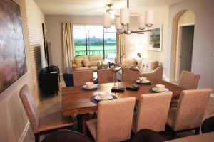 uma sala de jantar e sala de estar com mesa e cadeiras em Gorgeous 3Br Condo 10 min Disney, Golf Water Park em Kissimmee