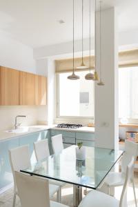 a kitchen with a glass table and white chairs at Adorable 2 bedrooms apt w Bomb Shelter next to the beach in Tel Aviv