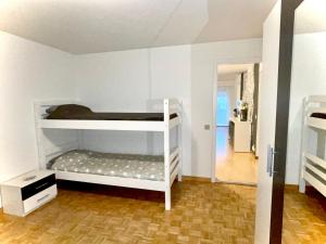 a room with two bunk beds and a hallway at Center Appartement Interlaken in Interlaken