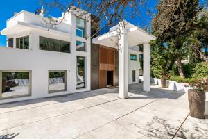 een wit huis met grote ramen en een patio bij All About Villa Serenity in Marbella