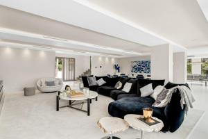 een woonkamer met een zwarte bank en een tafel bij All About Villa Serenity in Marbella