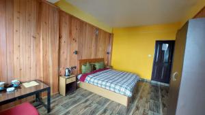 a small bedroom with a bed and a table at Pahari Soul in Darjeeling