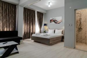 a bedroom with a king sized bed and a shower at Cappo Aparthotel in Veliko Tŭrnovo