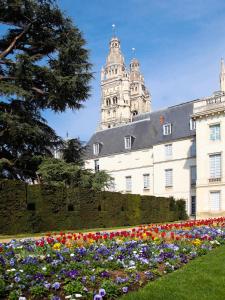 ein großes Gebäude mit einem Blumengarten davor in der Unterkunft La Maison Jules in Tours