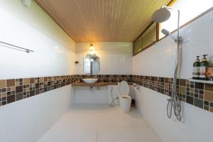 a bathroom with a sink and a toilet and a mirror at Karaboon Wellness in Phitsanulok