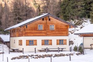 una cabaña de madera en la nieve en Chalet Neuhofalm Obertauern mit Sauna und Hobbyraum, en Obertauern